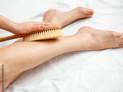 girl on a white sheet doing beauty procedures body scrub dry brush