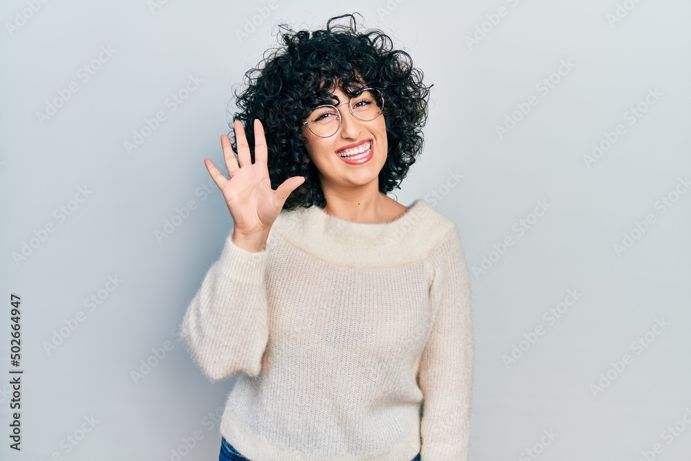 Young middle east woman wearing casual white tshirt showing and pointing up with fingers number five while smiling confident and happy. Young middle east woman wearing casual white tshirt showing and pointing up with fingers number five while smiling confident and happy.