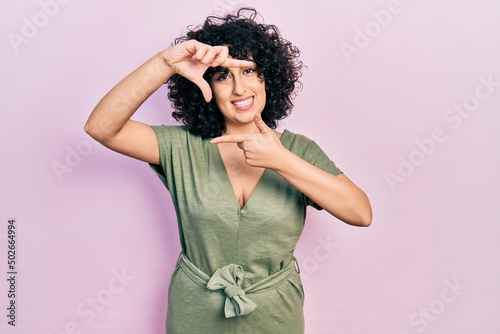 Young middle east woman wearing casual clothes smiling making frame with hands and fingers with happy face. creativity and photography concept.