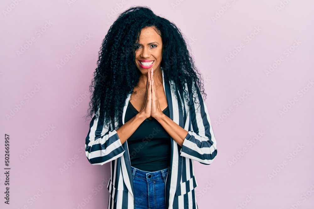 Middle age african american woman wearing casual clothes praying with hands together asking for forgiveness smiling confident. Middle age african american woman wearing casual clothes praying with hands together asking for forgiveness smiling confident.