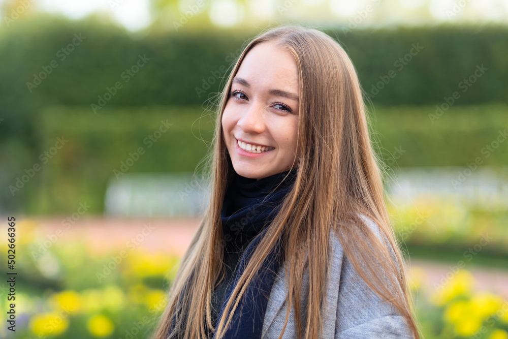 smiling girl with long hair in park on green natural background. portrait young attractive woman with snow-white smile in summer, autumn, spring smiling girl with long hair in park on green natural background. portrait young attractive woman with snow-white smile in summer, autumn, spring