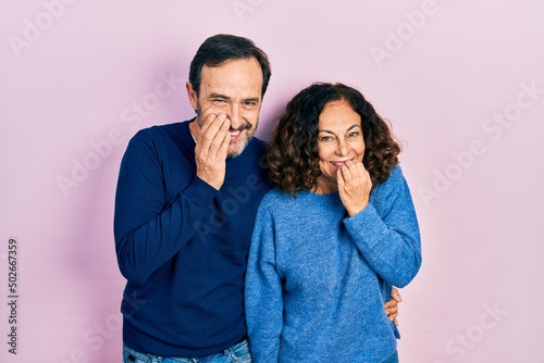 фотографія Middle age couple of hispanic woman and man hugging and standing together laughi