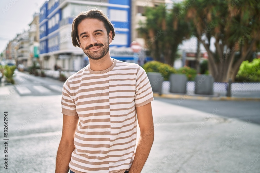 Young hispanic man smiling confident at street