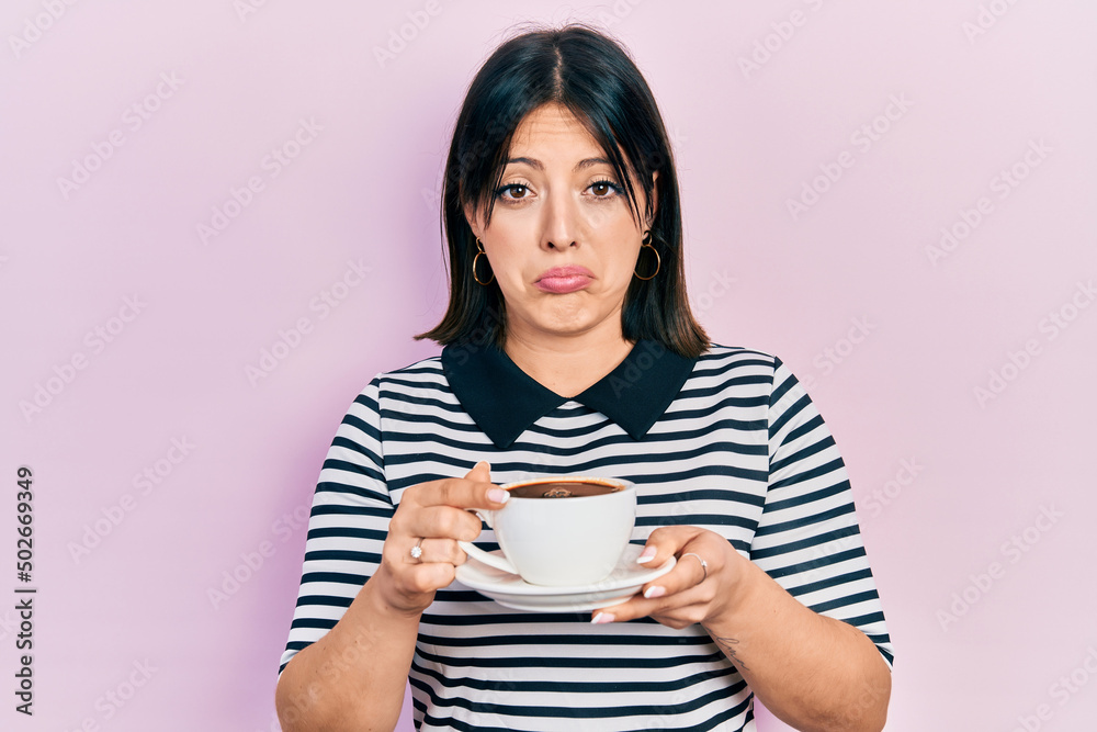 Young hispanic woman drinking a cup of coffee depressed and worry for distress, crying angry and afraid. sad expression. Young hispanic woman drinking a cup of coffee depressed and worry for distress, crying angry and afraid. sad expression.