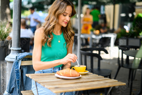 Woman having breakfast outdoor in a city center