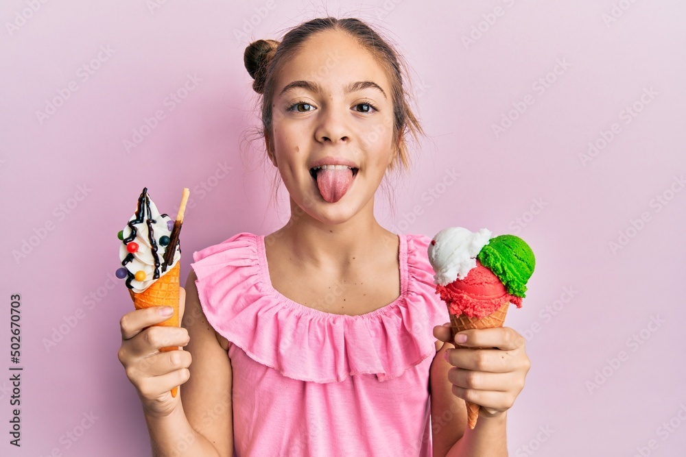 Beautiful little girl eating ice cream cones sticking tongue
