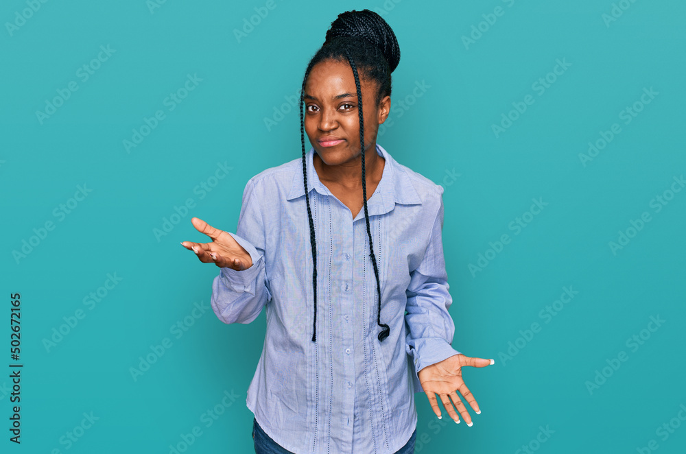 Young african american woman wearing casual clothes clueless and confused expression with arms and hands raised. doubt concept. Young african american woman wearing casual clothes clueless and confused expression with arms and hands raised. doubt concept.