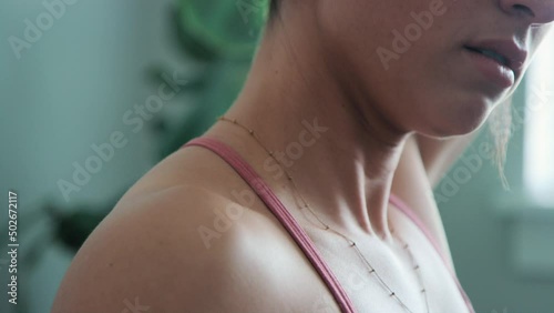 Hispanic woman adjusts hair in preparation for workout, handheld camera photo