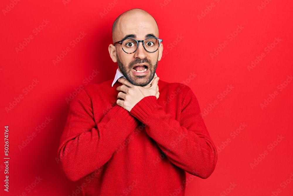 Fototapeta premium Young bald man wearing casual clothes and glasses shouting and suffocate because painful strangle. health problem. asphyxiate and suicide concept.