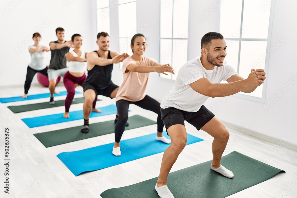 Group of young hispanic people smiling happy training legs exercise at sport center. Group of young hispanic people smiling happy training legs exercise at sport center.