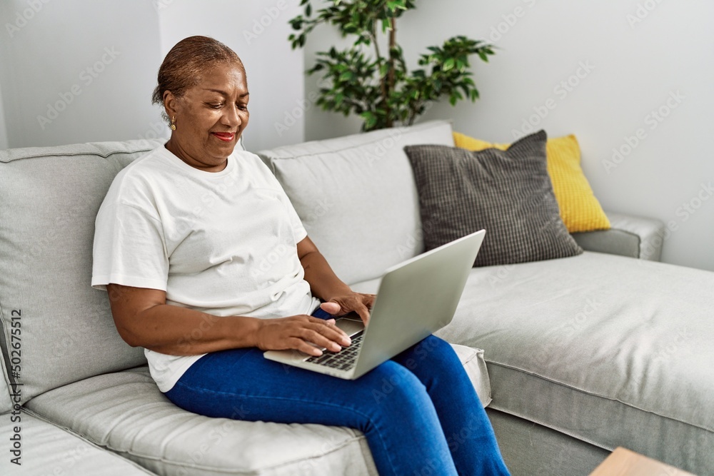 Senior african american woman smiling confident using laptop at home
