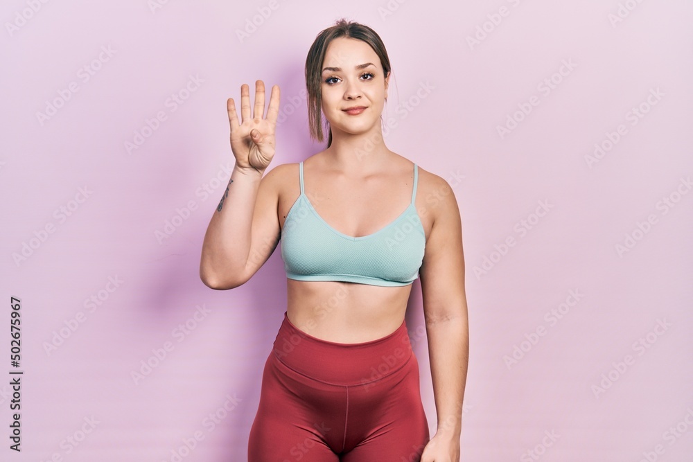 Young hispanic girl wearing sportswear showing and pointing up with fingers number four while smiling confident and happy. Young hispanic girl wearing sportswear showing and pointing up with fingers number four while smiling confident and happy.