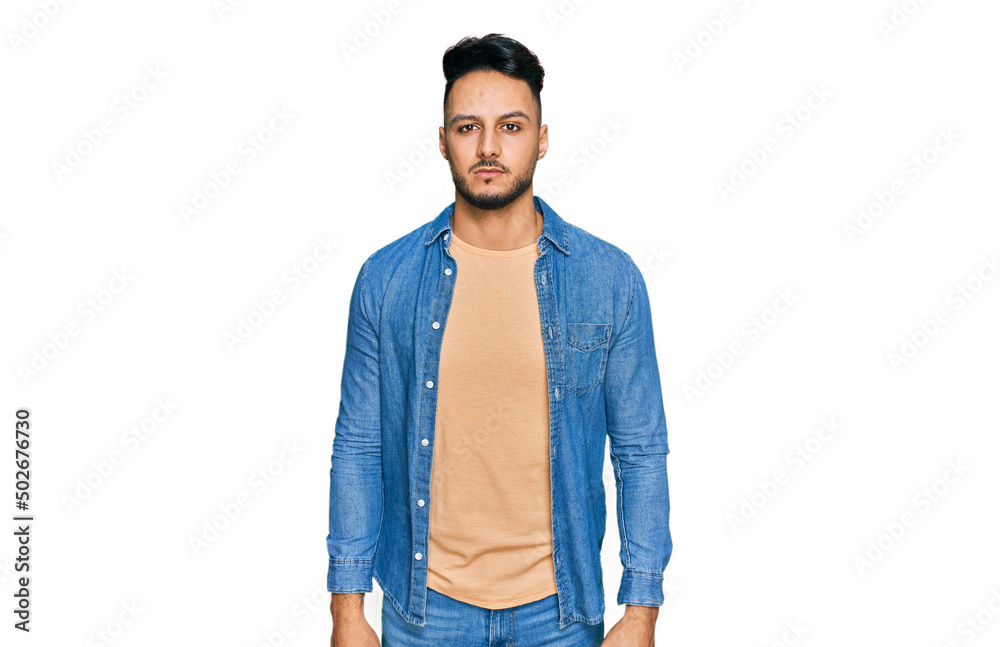 Fototapeta premium Young arab man wearing casual clothes with serious expression on face. simple and natural looking at the camera.