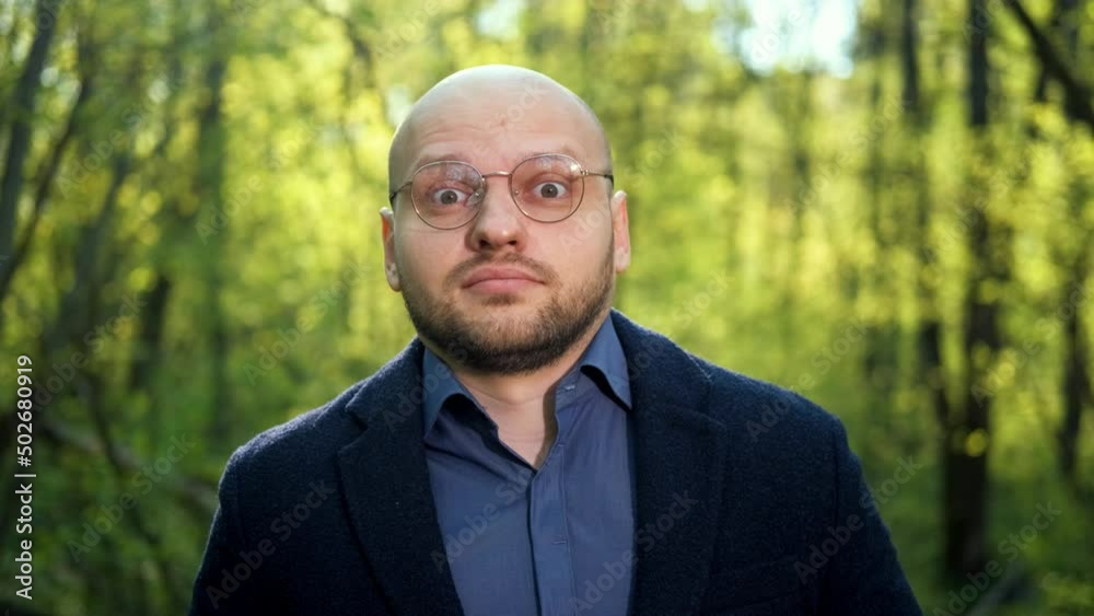 A wonderful nerd man adjusts his glasses, rolls his eyes and looks around suspiciously. Funny facial expressions A wonderful nerd man adjusts his glasses, rolls his eyes and looks around suspiciously. Funny facial expressions