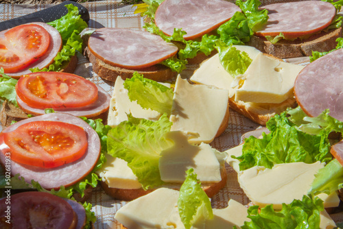 picnic in nature, sandwiches with cheese and sausage, tomato and lettuce