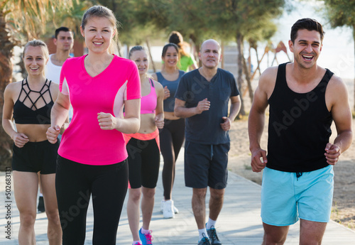 Fototapeta Naklejka Na Ścianę i Meble -  Active smiling people during running training in daytime