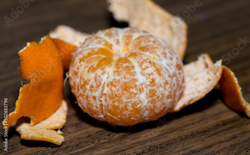 Removing the peel from the tangerine. Cleaning citrus fruits.