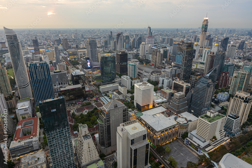 Fototapeta premium Aerial view of Ploenchit junction with cars traffic skyscraper buildings. Bangkok City in downtown at night, Thailand