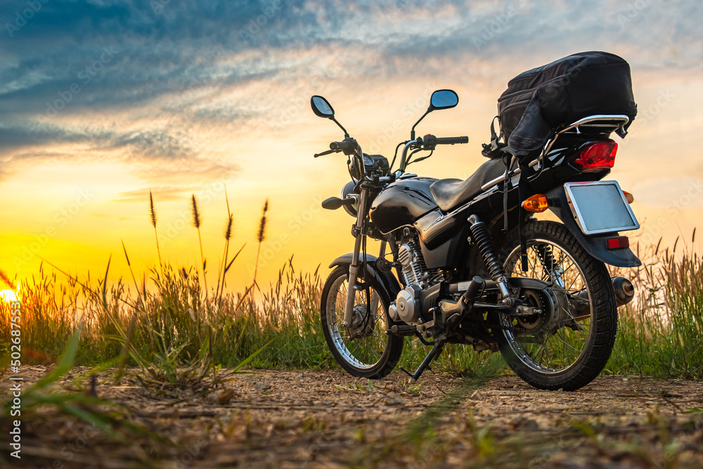 Black retro motorcycle with backpack parked outdoors. Black retro motorcycle with backpack parked outdoors.