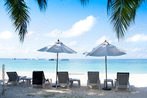 Five chairs and two white umbrella on the beach. Blue sky, Banner, lots of copy space