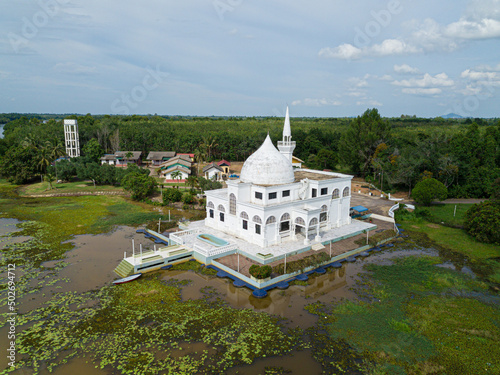 Drone shot of a white mosque from high angle view at Danau Tok Uban, Tanah Merah, Kelantan, Malaysia. photo