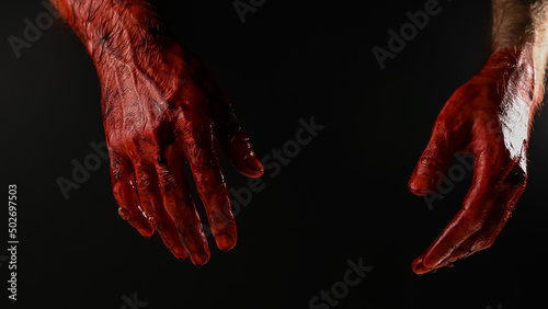 Male bloody hands on a black background. 
