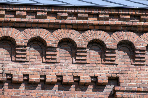 Fragment of the facade of an old brick building on a spring day photo