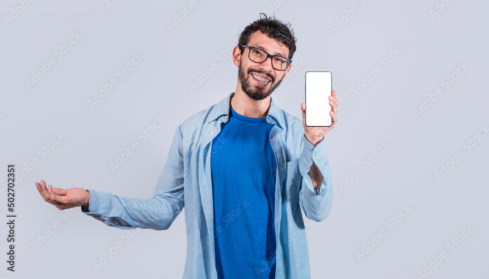 Handsome man smiling positive showing mobile phone blank screen with another hand palm open, excited happy male holding smartphone Handsome man smiling positive showing mobile phone blank screen with another hand palm open, excited happy male holding smartphone