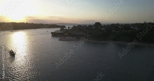 Plataran l'Harmonie Bay, Bali, Indonesia. Aerial drone view. Flight toward the coastline at sunset, Java island and Raung volcano on the horizon. photo