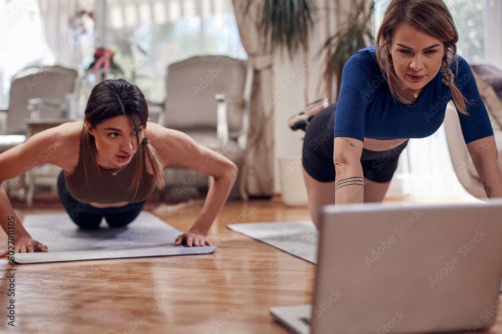 Pretty women working out at home. Adult ladies with beautiful shaped bodies exercising in the apartment. Pretty women working out at home. Adult ladies with beautiful shaped bodies exercising in the apartment.
