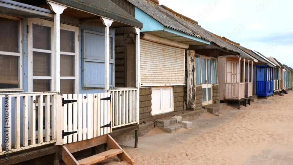 Tired old rusty beach huts on the promenade in Sutton-on-sea. Tired old rusty beach huts on the promenade in Sutton-on-sea.