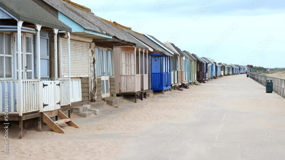 Tired old beach huts on the promenade in Sutton-on-sea. Tired old beach huts on the promenade in Sutton-on-sea.