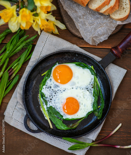 Obraz na płótnie Fried eggs with fried green wild garlic