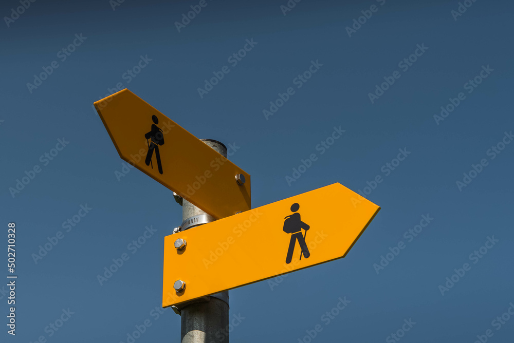 Two yellow signposts with walking figures and arrows point in different directions, Canton Thurgau, Switzerland