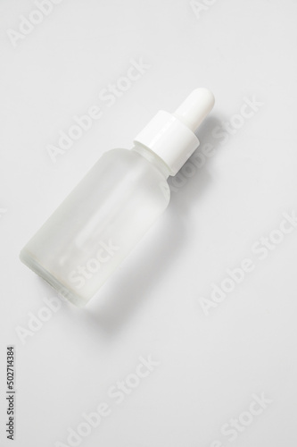 Glass matte bottle cosmetic droper on neutral background. Skin care oils, vitamins, collagen. Packaging of cosmetic beauty product, pack shot, copy space