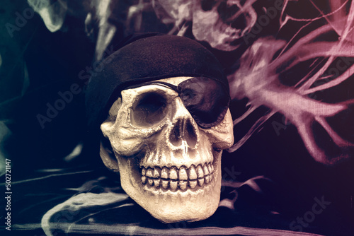 Skull with eye patch and black headscarf. Pirate skull on dark background. photo