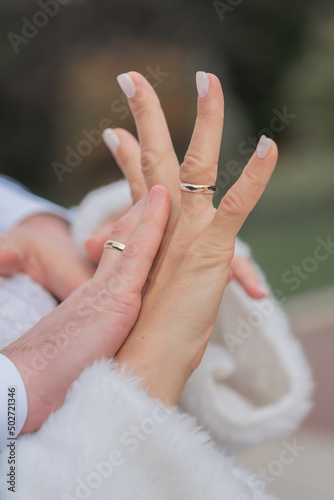.palms of the bride and groom with wedding rings