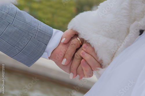 .bride's hand with wedding ring in the groom's hand