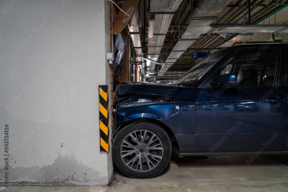 Obraz premium Huge SUV drove into a door in the wall in an underground parking lot at speed