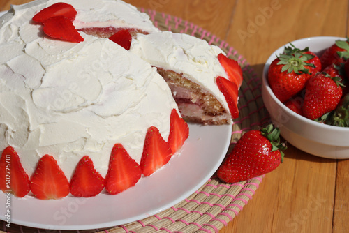 Cut Zuccotto, traditional italian dome shaped cake with white chocolate  and strawberries cream on wooden table. Charlotte cake with strawberries photo