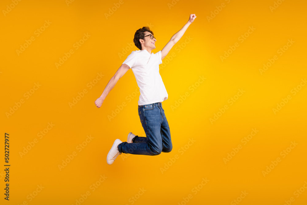 Full body profile side photo of young guy good mood jump fly superman power isolated over yellow color background