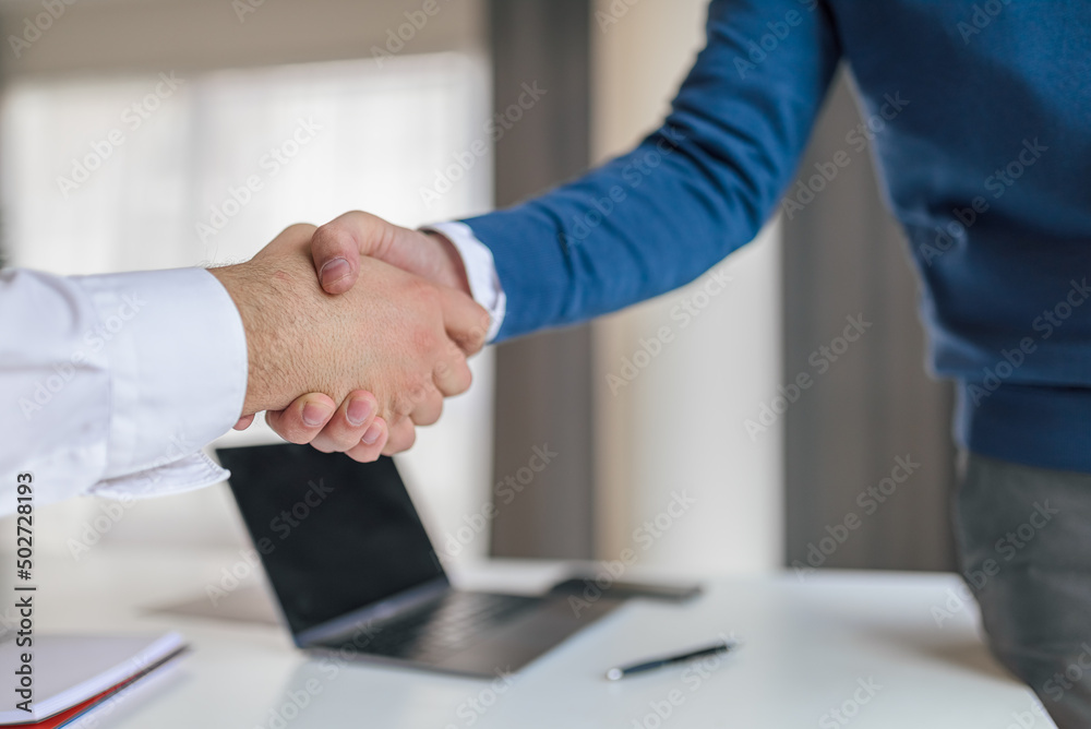 Business partners shaking hands for successful deal at corporate office