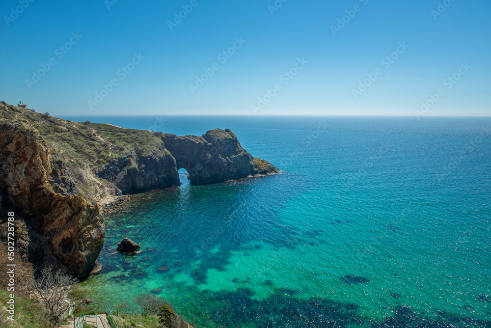 Top view of the Black Sea coast near steep mountains with turquoise water