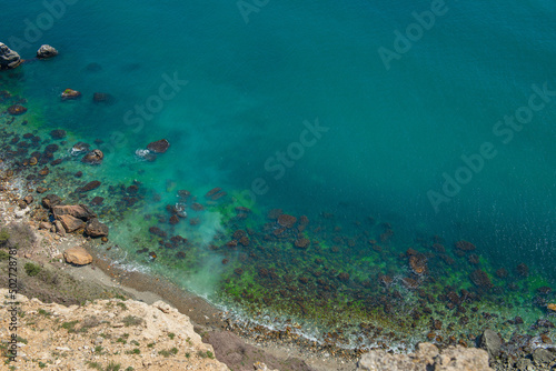 Top view of the rocky coast of the sea with turquoise water.