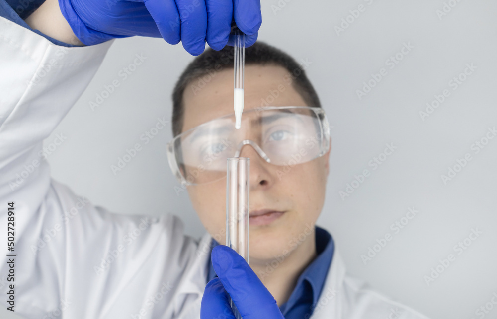Medical laboratory assistant checks a test tube with sperm. Spermogram