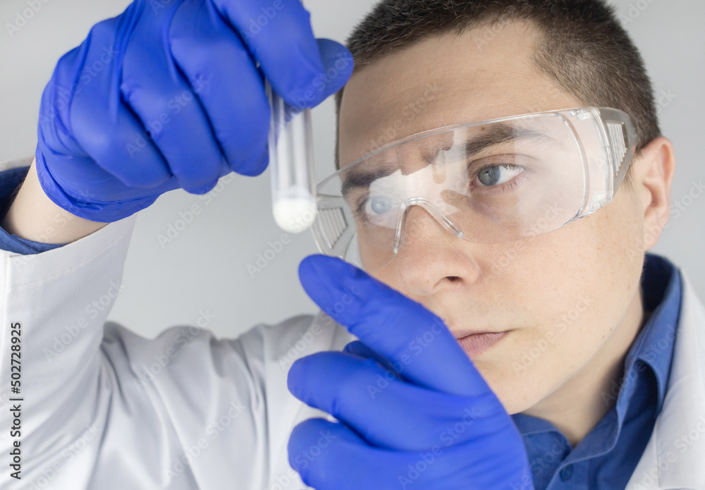 Medical laboratory assistant checks a test tube with sperm. Spermogram