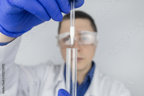 Medical laboratory assistant checks a test tube with sperm. Spermogram. Male fertility test. Semen in a test tube. Reproductive system check. Donor suitability test for artificial insemination