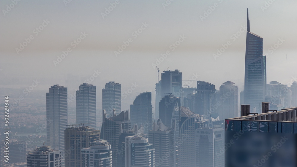 Fog covered skyscrapers in JLT district aerial timelapse.