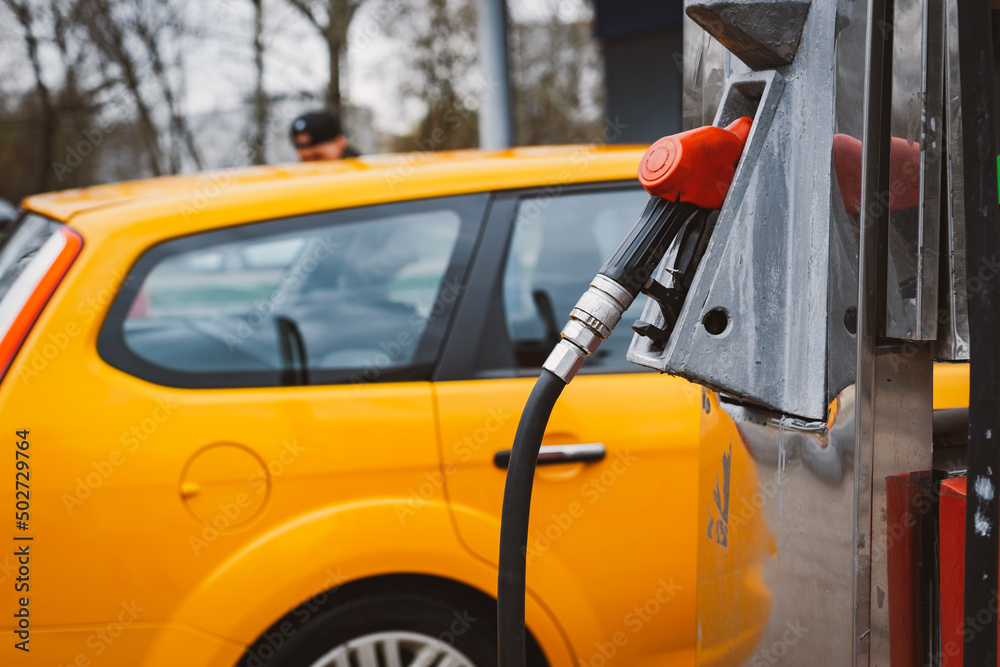 Unrecognizable man refueling car from gas station filling benzine gasoline fuel in car at gas station. Petrol high prices concept Unrecognizable man refueling car from gas station filling benzine gasoline fuel in car at gas station. Petrol high prices concept