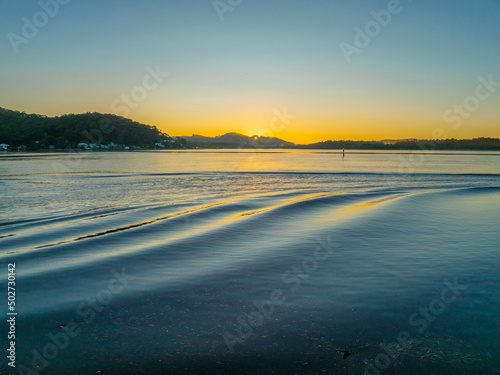 Clear skies sunrise and ripples at the waterfront